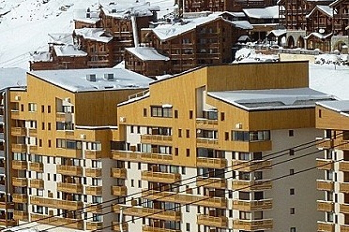 A ski resort with a lot of buildings covered in snow