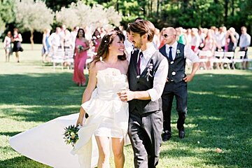 A bride and groom are walking down the aisle at their wedding
