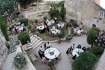 A group of people are sitting at tables in a courtyard