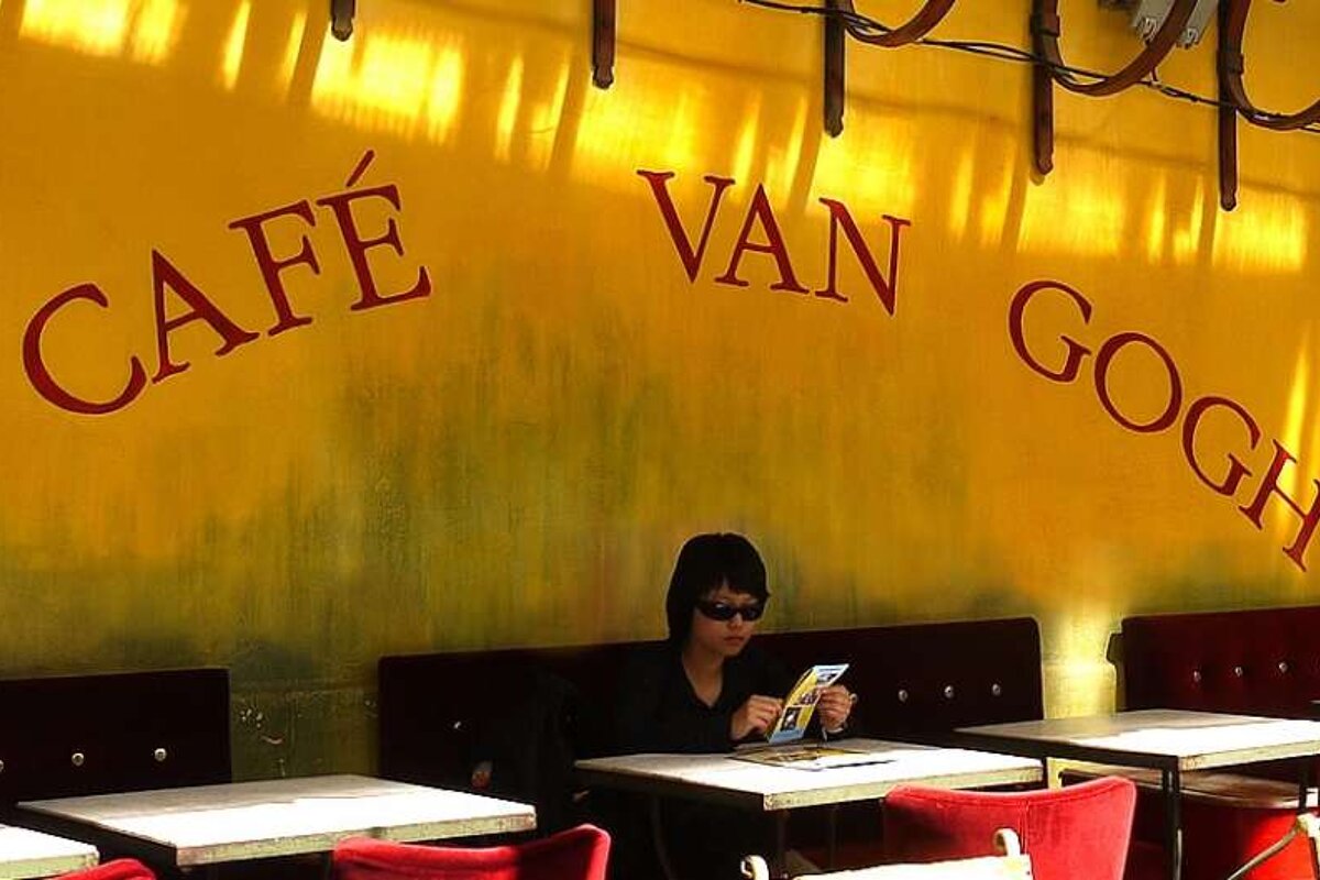 a photo of a cafe with a girl reading a book