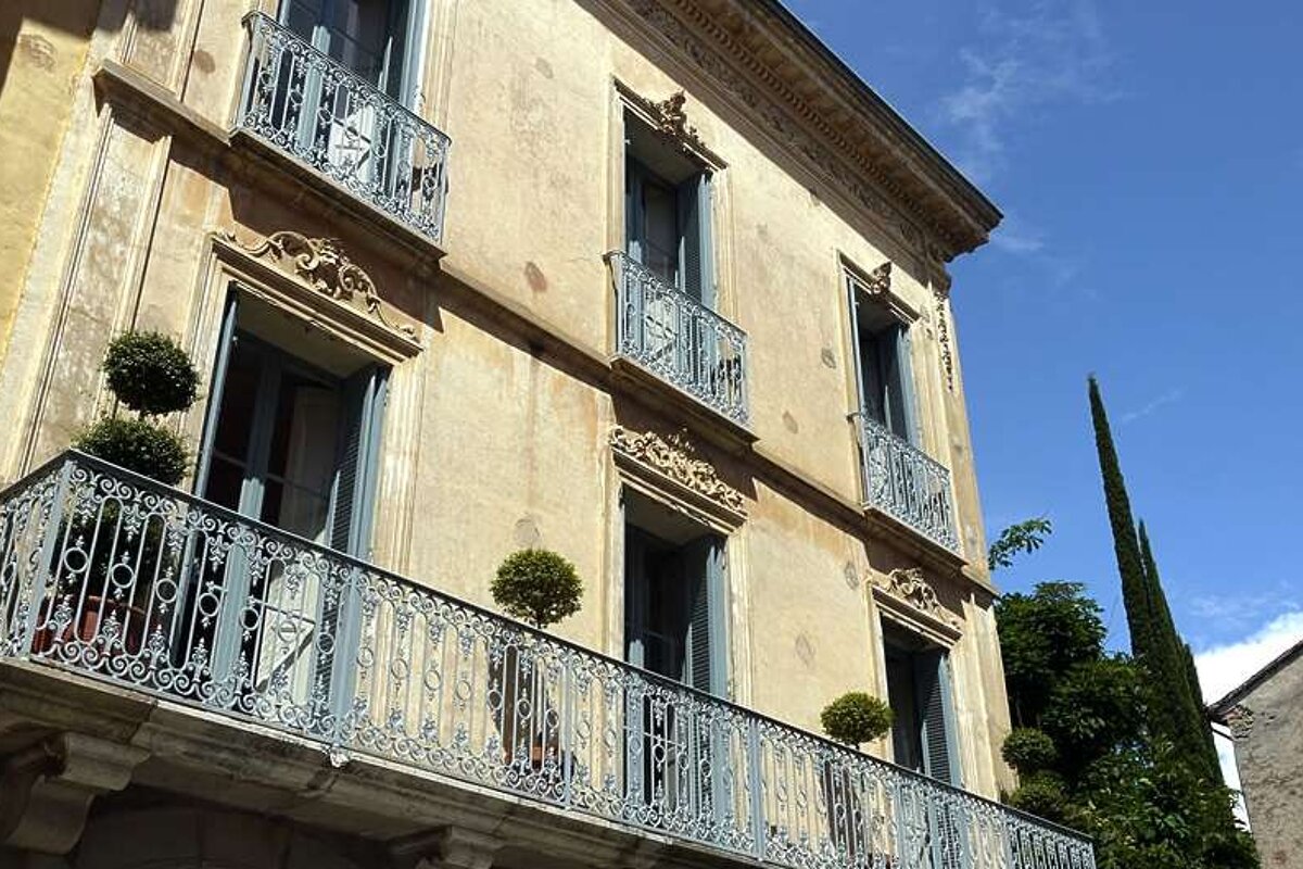 an image of a classic stone house with french balconies
