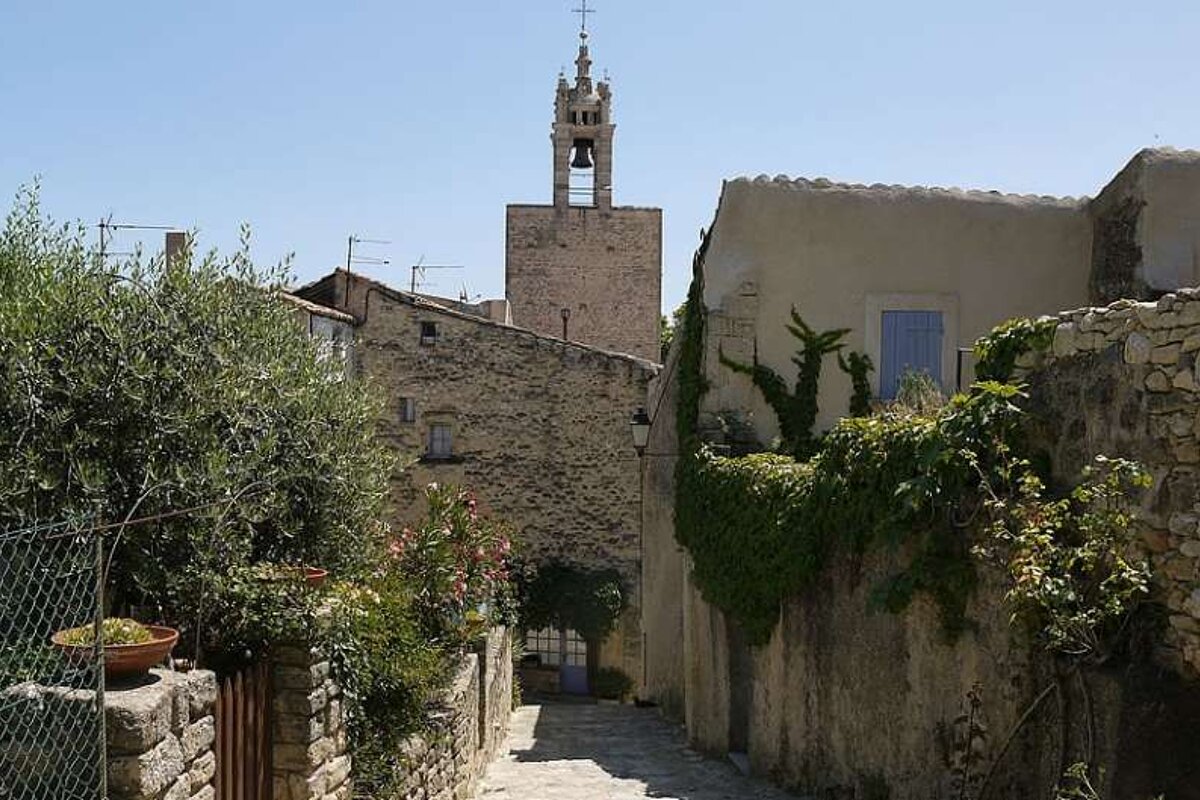 an image of a village lane with a church bell tower