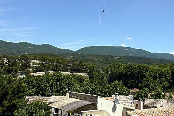 an image of a village and the green hilly countryside