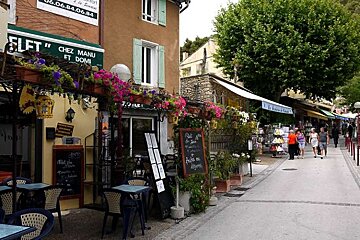 a photo of a street with cafes and shops