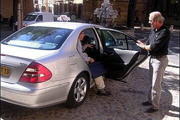 mercedes taxi with man opening door and pasenger exiting
