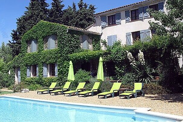House with swimming pool and yellow deck chairs