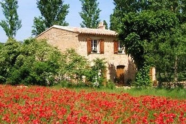 House from Provence in a field with poppies