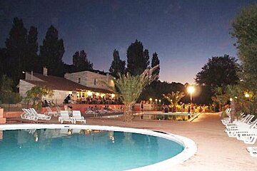 swimming pool with building and people in the background at night