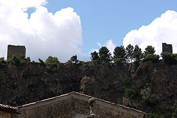photo of a cliff face with two ruined towers on top