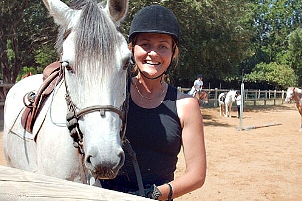 woman by her horse in training paddock