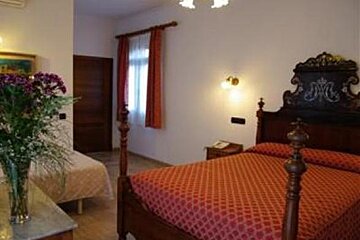 an image of a room with a bed with turned wooden posts at the foot end