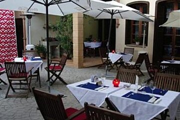 an image of a garden courtyard with 2 white parasols