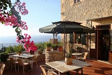 A patio with tables and chairs and a large umbrella