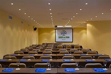 an image of a large room with rows of tables and chairs facing a projector screen