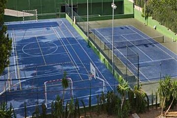 an image of 2 playing courts for tennis and football fenced with railings