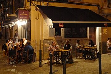 Bar with people drinking outside at night