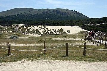 photo of sand dunes with paths and a hill