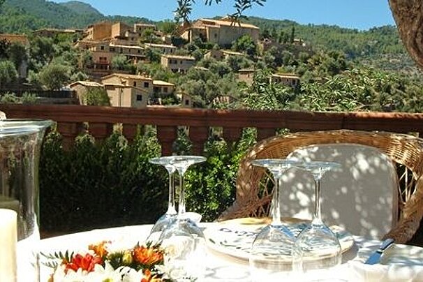 photo of a dining table overlooking a village