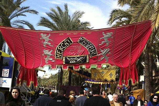 A crowd of people are gathered under a banner that says verch medina