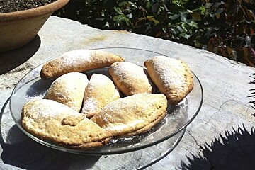 A plate of pastries with powdered sugar on them