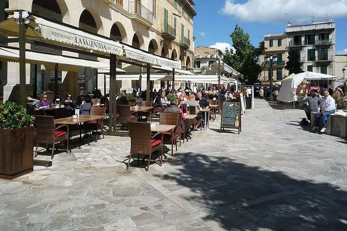 People sit at tables outside of a restaurant called la ventana