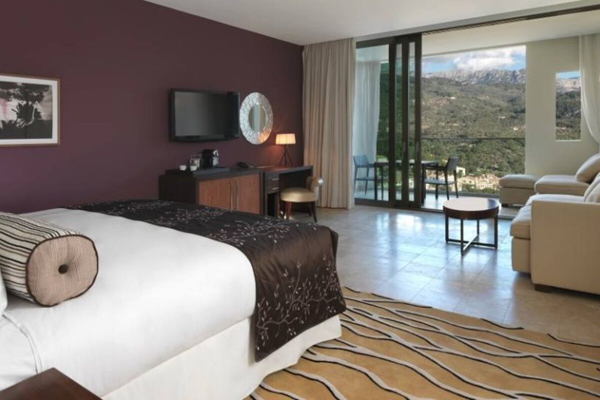 an image of a double bedroom with a patterned rug and a mountain view