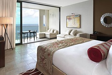 an image of a room with a sea view through large windows