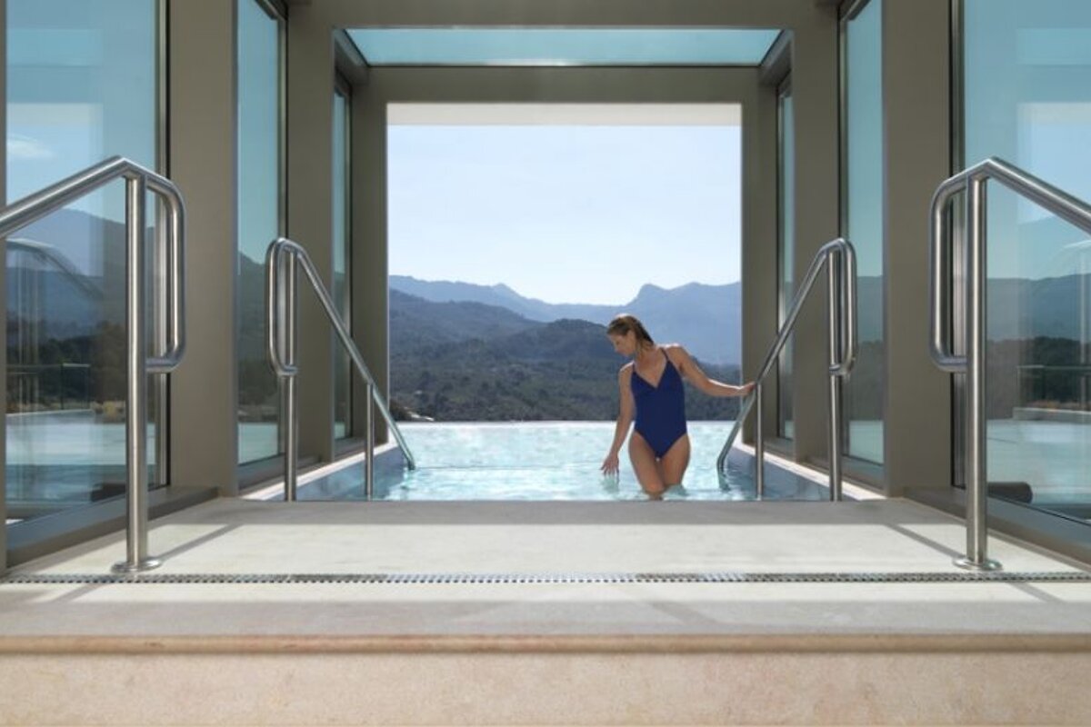 an image of a woman stepping out of a hydro pool with lots of windows