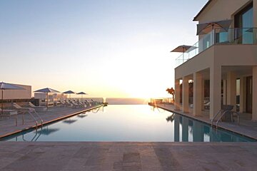 an image of an infinity pool at a hotel at sunset