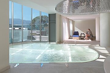 an image of an indoor swimming pool with lights and water jets