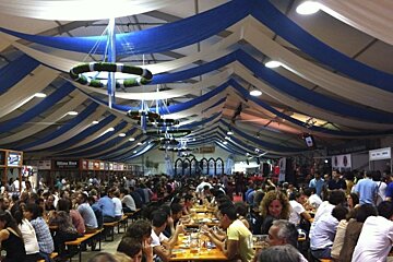 an image of a tent interior filled with people and trestle tables