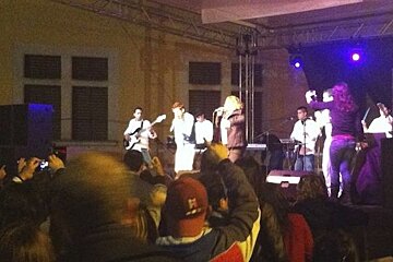 photo of people watching a band on a stage