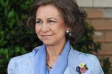 A woman in a blue jacket and scarf is smiling
