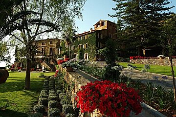 a photo of a garden and a large house