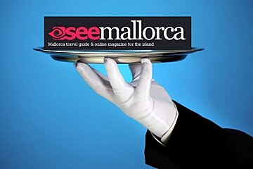 a picture of a butlers hand holding a silver platter with our logo on