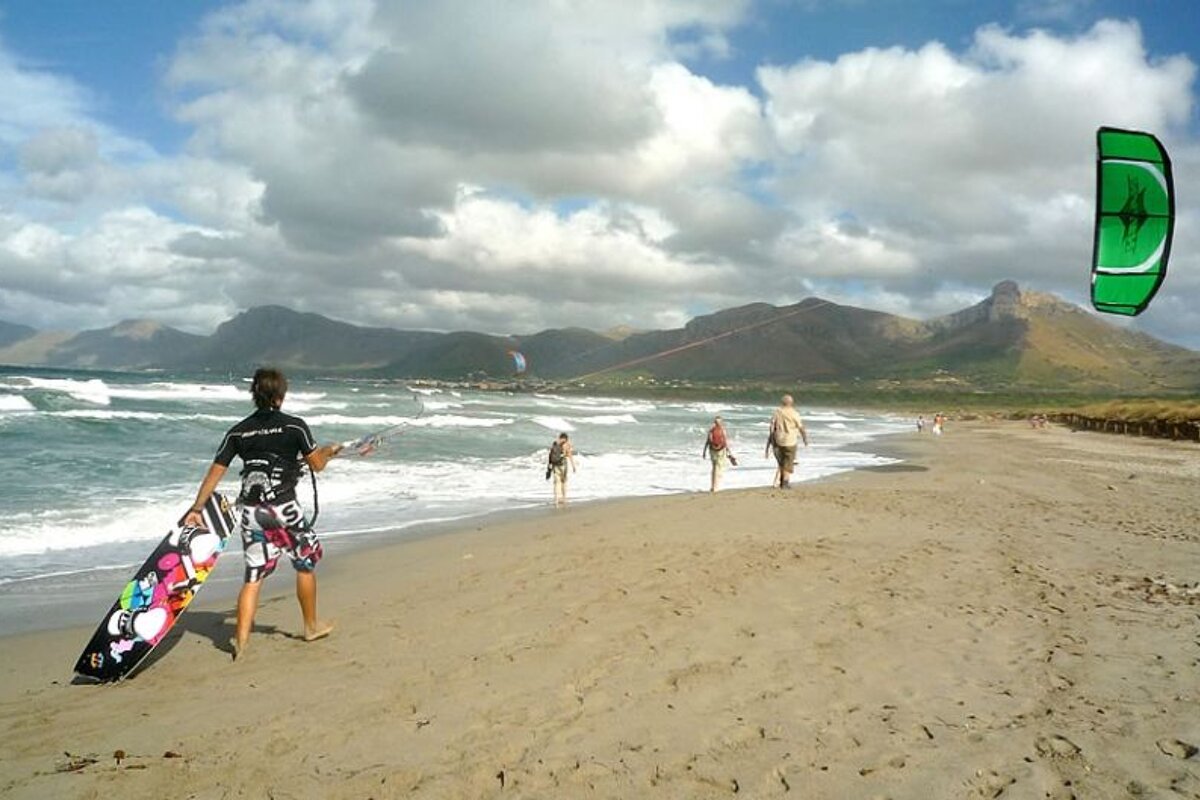 photo of a beach and sea and a kite surfer