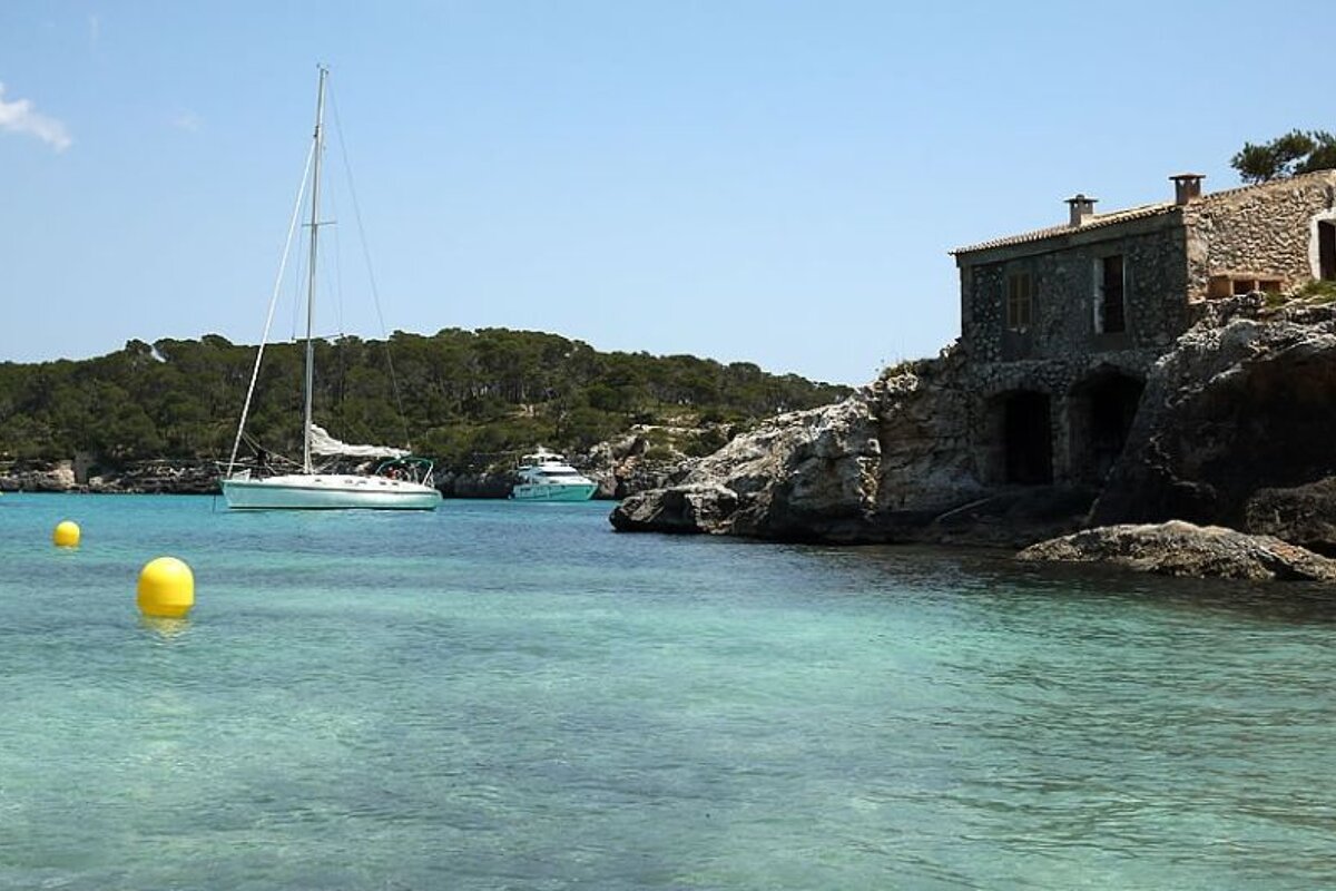 photo of sea and yachts and a cottage