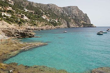 bay with clear water and some boats