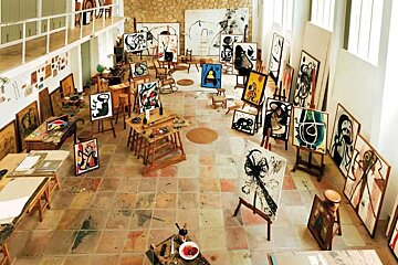 An artist 's studio filled with paintings and easels