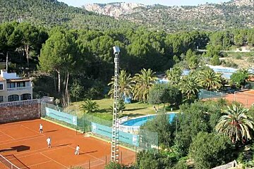 an image of a tennis club with clay courts and lots of trees