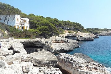 house on the rocky coast line blue water