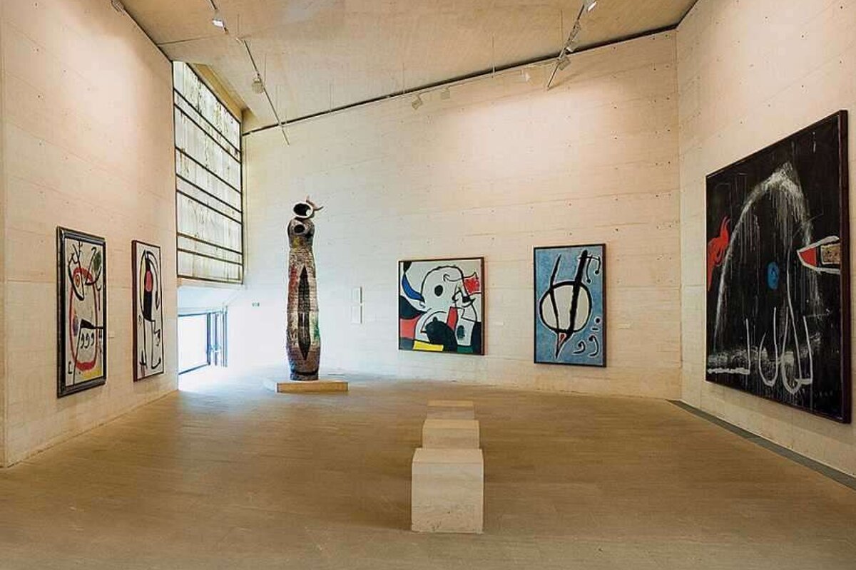A large room with paintings on the wall and a statue in the middle