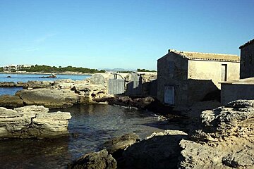 a photo of a deserted cottage by the sea