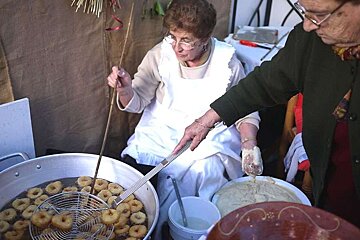 a photo of bunyols being deep fried by two majorcan ladies