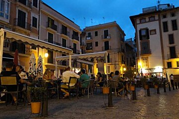 people in placa at night sitting 