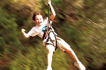 a photo of a child pn a zip wire