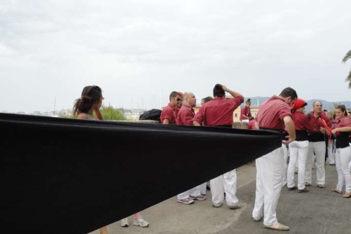 A group of people are standing around a large black object
