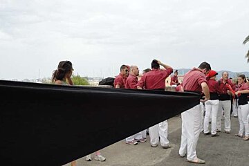 A group of people are standing around a large black object