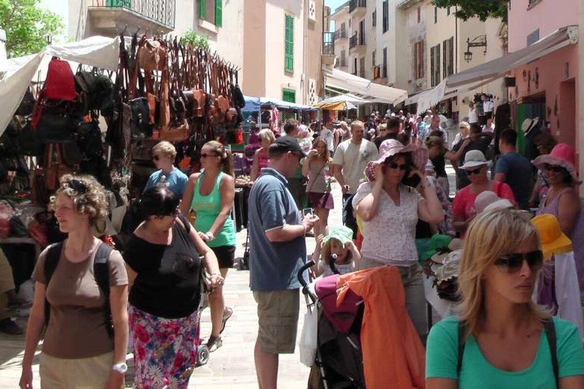 market stalls and a busy street on market day in alcudia