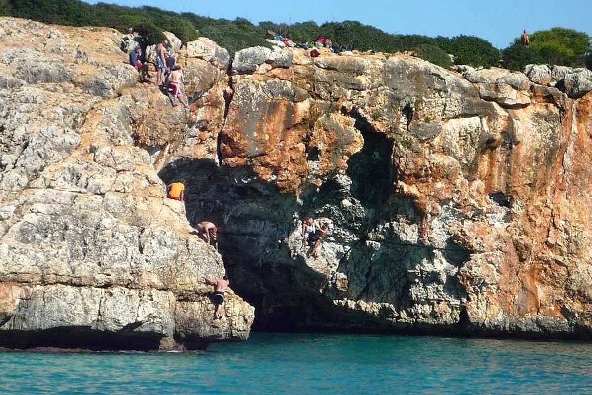 a photo of climbers in caves above the sea in majorca